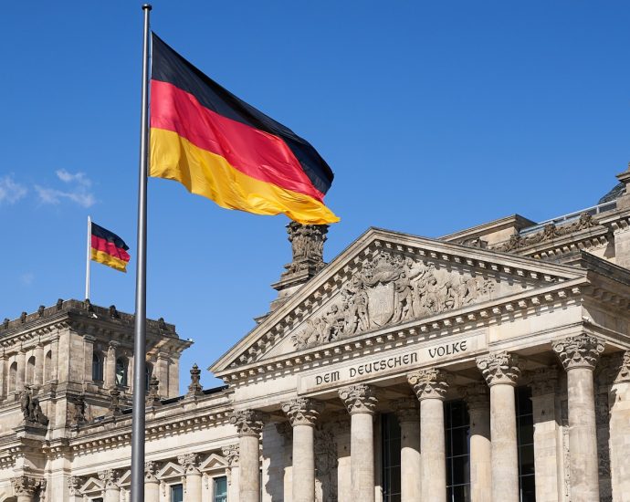 a german flag flying in front of a building