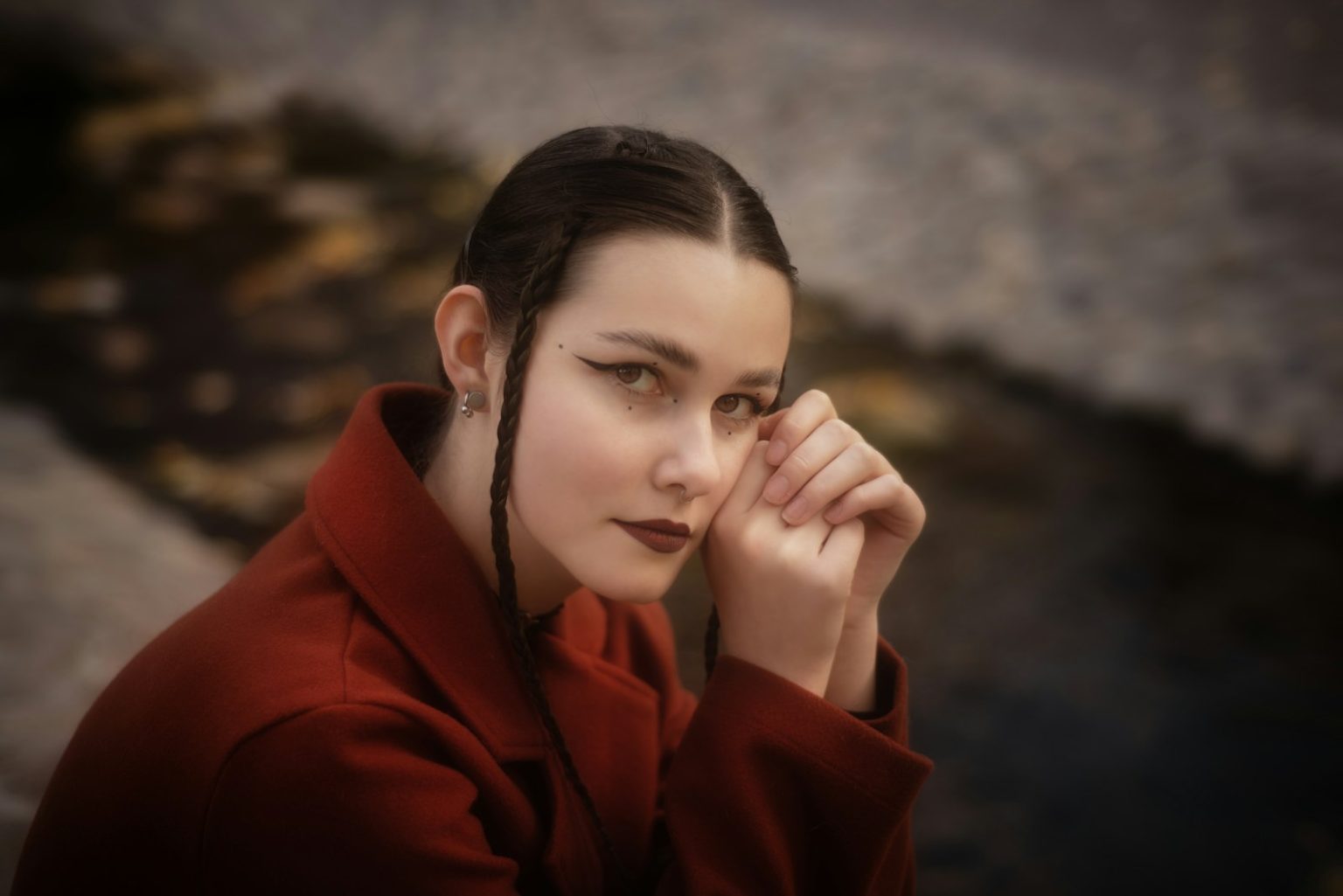 A woman poses with hands near her face.