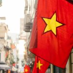 a red and yellow flag hanging from the side of a building