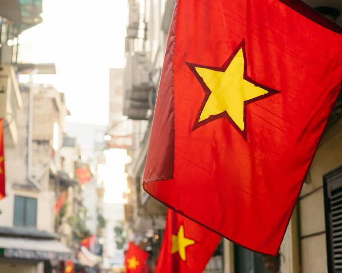 a red and yellow flag hanging from the side of a building