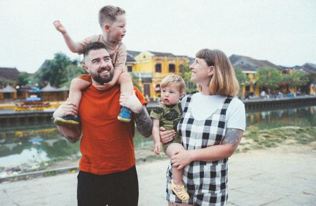 a man holding a child while standing next to two women and a child