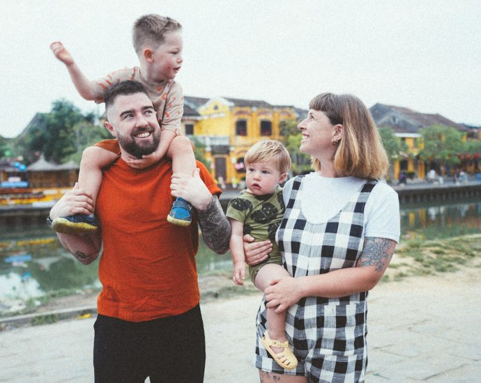 a man holding a child while standing next to two women and a child