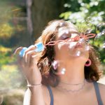A woman blows bubbles in the sun.