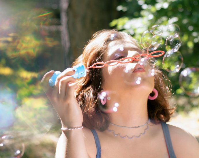 A woman blows bubbles in the sun.