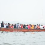 people in red boat on water during daytime