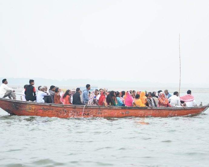 people in red boat on water during daytime