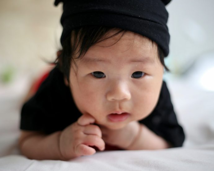 shallow focus photo of baby wearing black knit cap