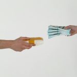 Conceptual image of a drug deal exchange showing money for a substance in two hands.
