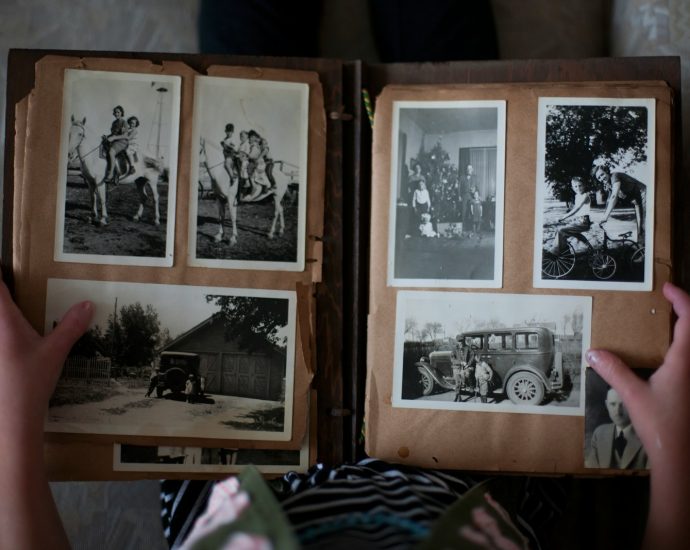 person opening photo album displaying grayscale photos