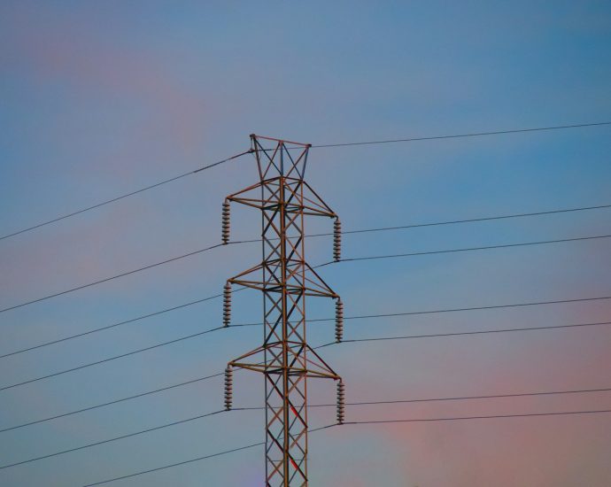 a high voltage power line against a blue sky