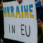 a person holding a sign that says ukraine in eu