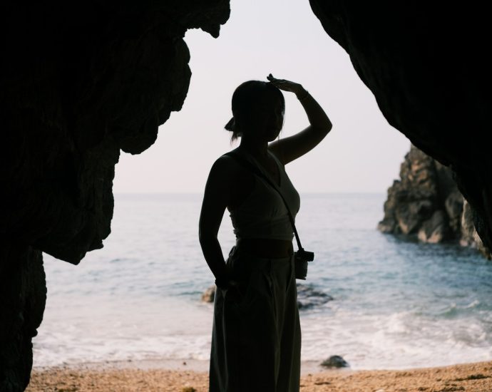 A woman silhouetted, looking out over the sea.