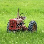 red tractor left in grass field
