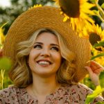 a woman in a sunflower field wearing a straw hat