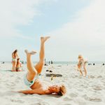 smiling man lying on white sand during daytime