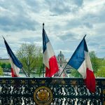 a fence with two flags on top of it