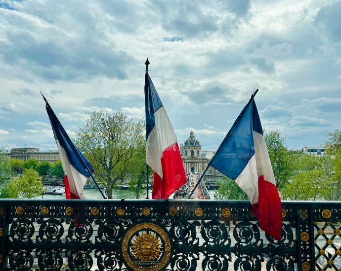 a fence with two flags on top of it