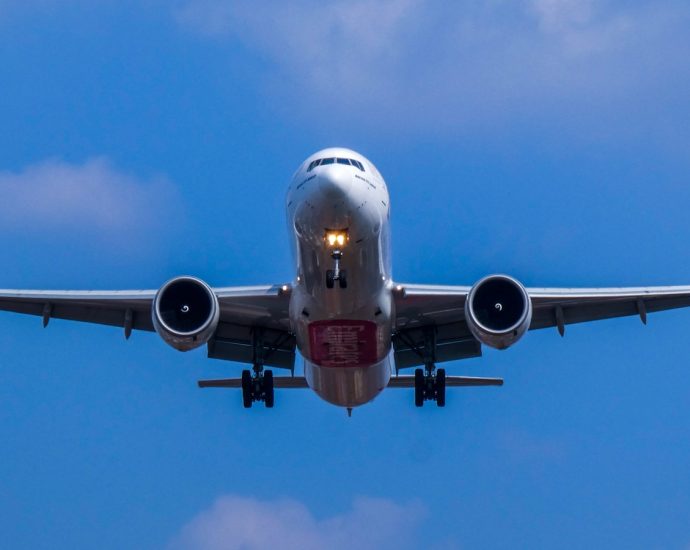white and blue airplane under blue sky during daytime
