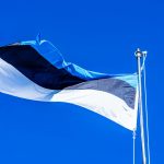 a flag flying in the wind on a clear day