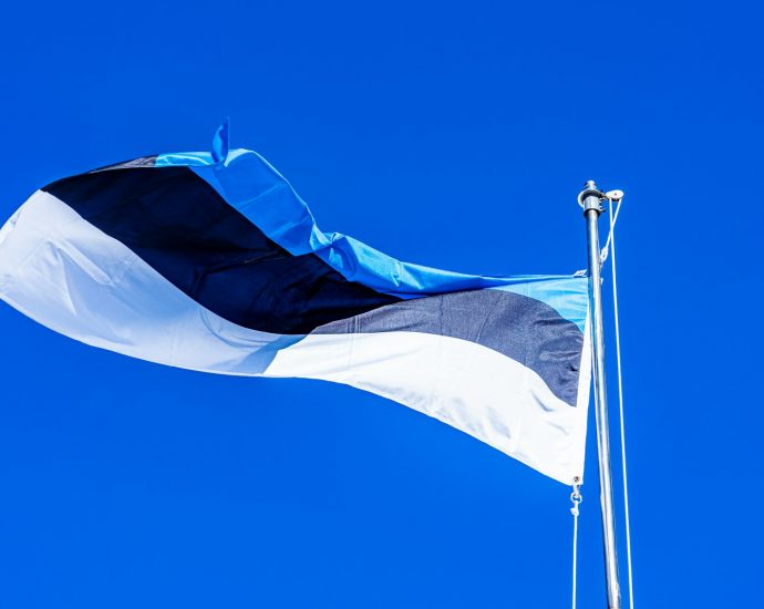 a flag flying in the wind on a clear day