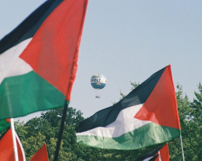 Palestinian flags with a Welt hot air balloon in Berlin, symbolizing awareness and protest.