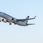 A large jetliner flying through a blue sky