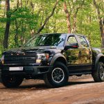 black and yellow chevrolet crew cab pickup truck parked on dirt road during daytime