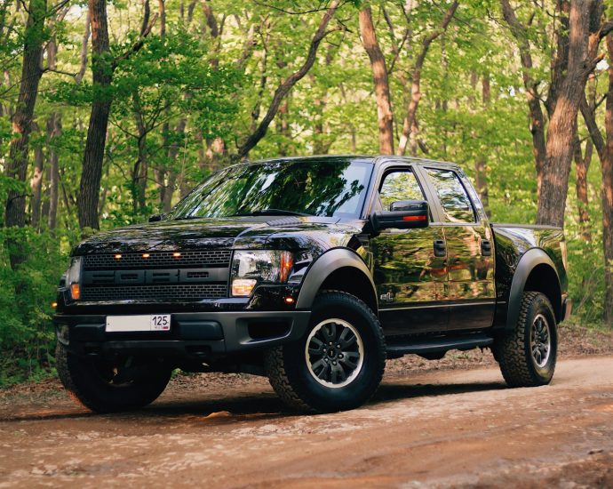 black and yellow chevrolet crew cab pickup truck parked on dirt road during daytime