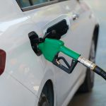 a white car with a green gas pump