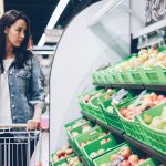 Woman shops for produce at a supermarket.
