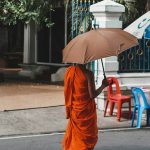 a person walking down a street holding an umbrella