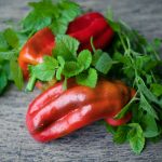a group of red peppers with green leaves