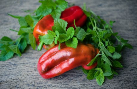 a group of red peppers with green leaves