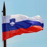 a flag flying in the wind on a pole