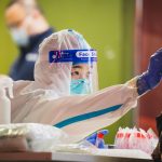 a person wearing a protective suit and holding a toothbrush
