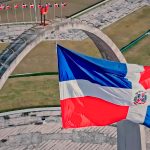 a flag flying in the air next to a bridge