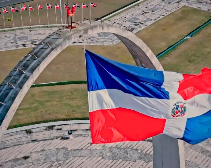 a flag flying in the air next to a bridge