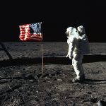 Buzz Aldrin on the moon in front of the US flag