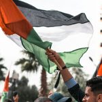 a man holding a flag in a crowd of people
