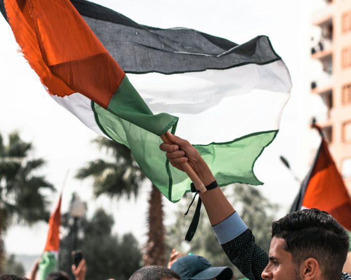 a man holding a flag in a crowd of people