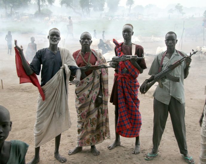 four men holding assault rifles