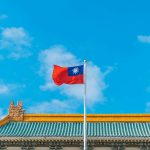 a red and blue flag on top of a building