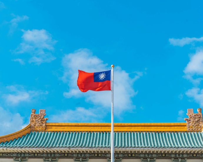 a red and blue flag on top of a building
