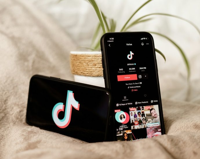 a couple of cell phones sitting on top of a bed