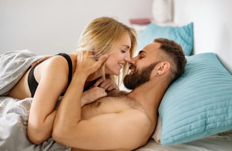 Intimate moment of a couple embracing and smiling warmly in bed.