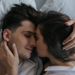 Close-up of a loving couple embracing and resting peacefully in bed.