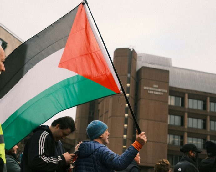 A man holding a flag in a crowd of people