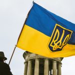 a man holding a flag in front of a building