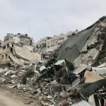a large pile of rubble next to a dirt road