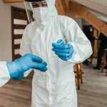 a person in a white suit and blue gloves